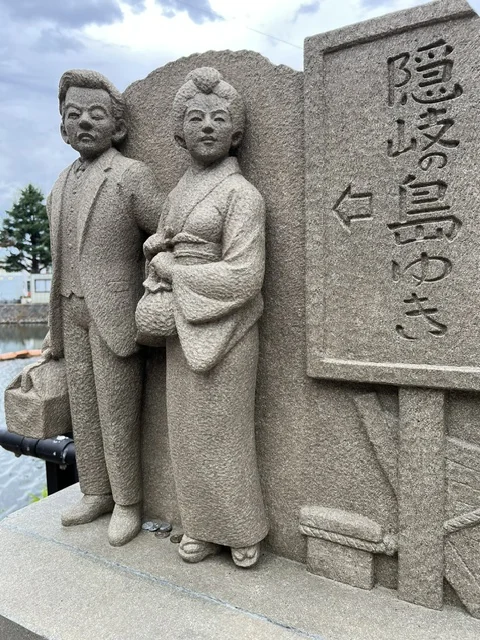 「八雲とセツ隠岐島の旅へ出発」の石像